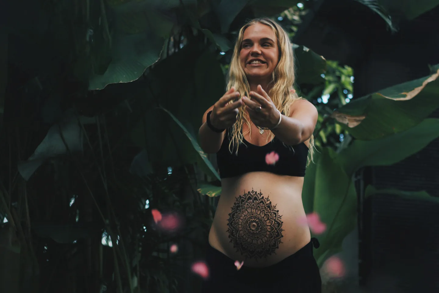 Maria Frisch reaching forward among tropical leaves in Bali